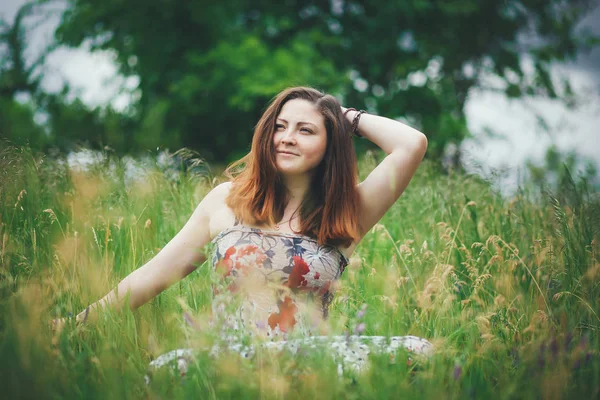 Woman lie on blue sky and green grass. — Stock Photo, Image