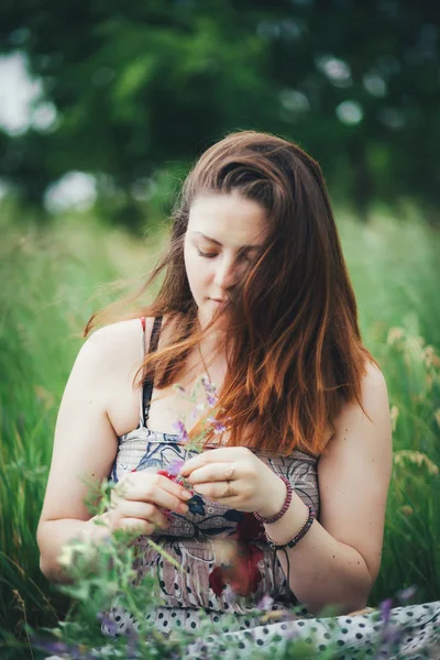 Jonge vrouw zittend op gras — Stockfoto