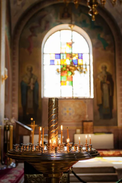 Burning candle in the church in front of the icons — Stock Photo, Image