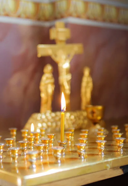 Burning candle in the church in front of the icons — Stock Photo, Image