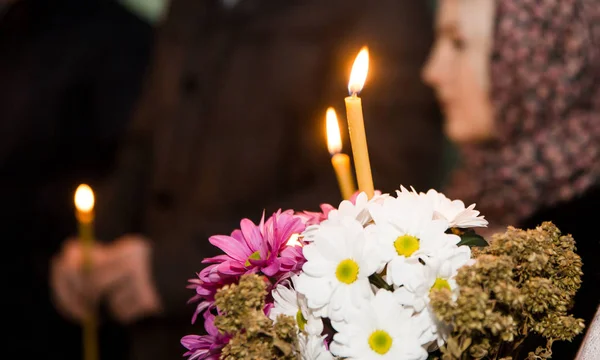 Burning candle in the church in front of the icons — Stock Photo, Image