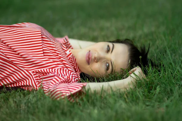 Flicka ligger på en gräsmatta — Stockfoto