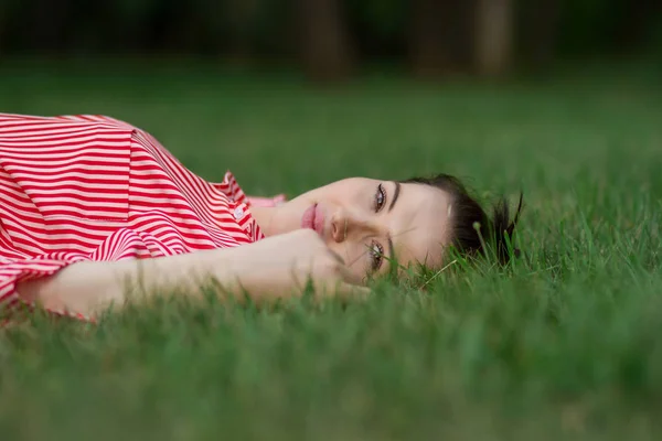 Menina encontra-se em um gramado — Fotografia de Stock