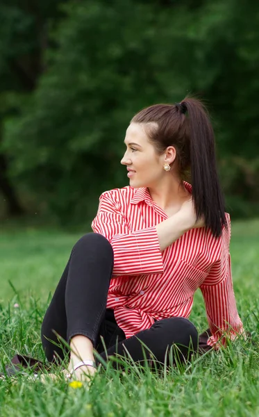 Girl sits on lawn — Stock Photo, Image