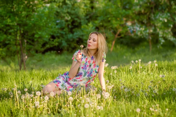 Femme dans le parc avec des pissenlits — Photo