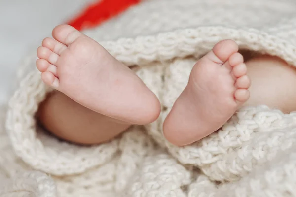 Close up de recém-nascido pés de bebê cobertos com o cobertor. — Fotografia de Stock