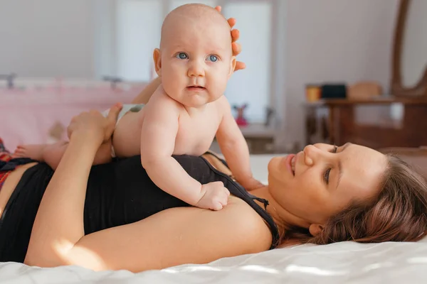 Mother playing with her baby boy son on bed. — 스톡 사진