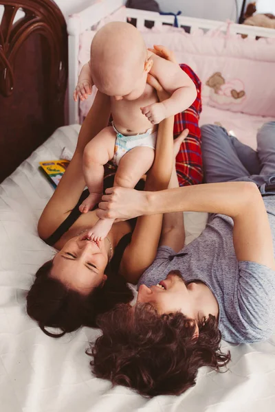 행복한 쾌활한 엄마와 아빠는 침대에서 귀여운 아기와 상단보기 — 스톡 사진