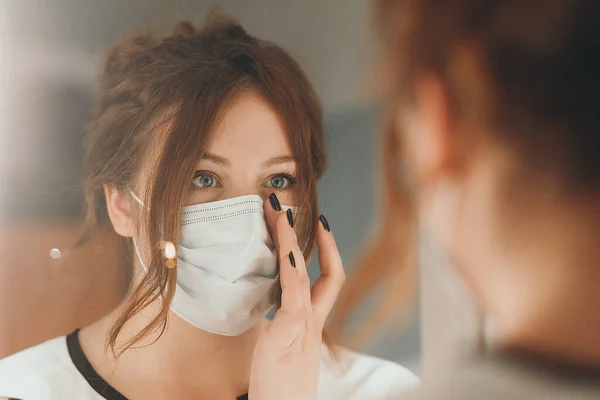 Light hair woman puts on medical mask for protection against virus