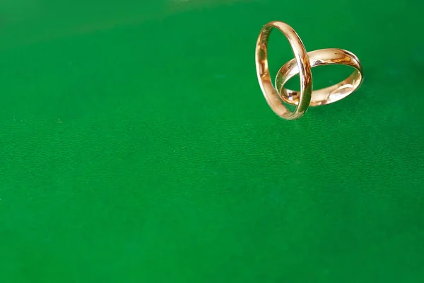 Два Золотых Обручальных Кольца Зеленом Фоне — стоковое фото