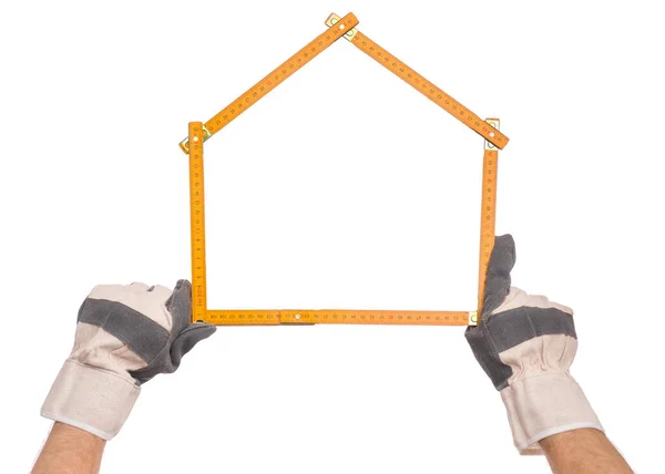 男手戴工作手套与黄色木制仪表 人手握工具形成房屋 在白色背景上隔离 — 图库照片
