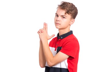 Komik genç çocuk portre silah jest çekim için hazırlanıyor yapıyor. Beyaz genç genç beyaz arka plan izole silah jest kaldırdı gösteren. Sembolik silah tutan bir çocuk. Duygular ve işaretler.