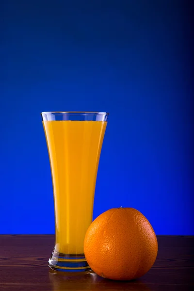 Φρέσκος χυμός πορτοκαλιού σε ξύλινο τραπέζι — Φωτογραφία Αρχείου