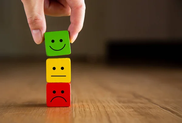 Müşteri hizmetleri değerlendirmesi ve memnuniyet araştırması konseptleri. Müşteri eli gülen surat ikonunu seçti..