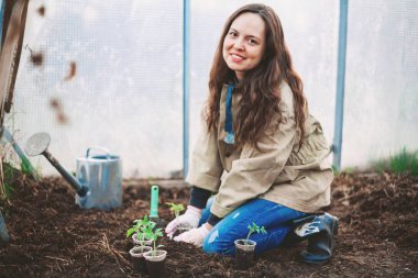 Genç bir kadın bir ağaç mı dikiyor.