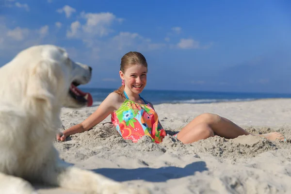 Heureuse fille jouer avec un chien sur la plage — Photo