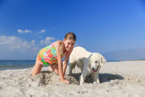 Ευτυχισμένος κορίτσι παίζει με ένα σκύλο στην παραλία — Φωτογραφία Αρχείου