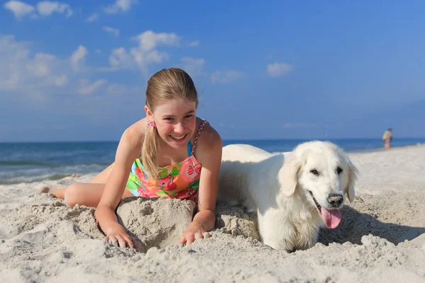mutlu kız sahilde bir köpekle oynamayı