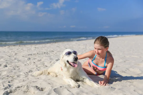 Chica feliz jugando con un perro en la playa — Foto de Stock