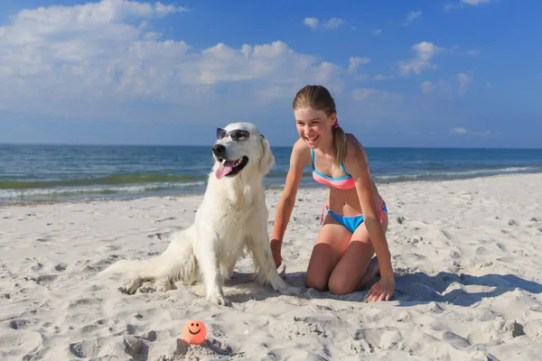 Heureuse fille jouer avec un chien sur la plage — Photo