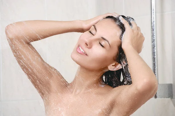 Happy young woman in shower Stock Image