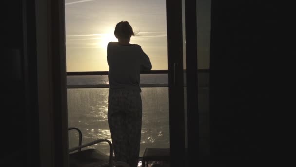Tonårstjej tittar på soluppgången från balkongen på kryssningsfartyg — Stockvideo