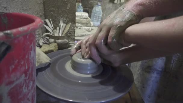 Potter shapes the clay product with pottery tools on the potters wheel, craft factory authentic — Stock Video