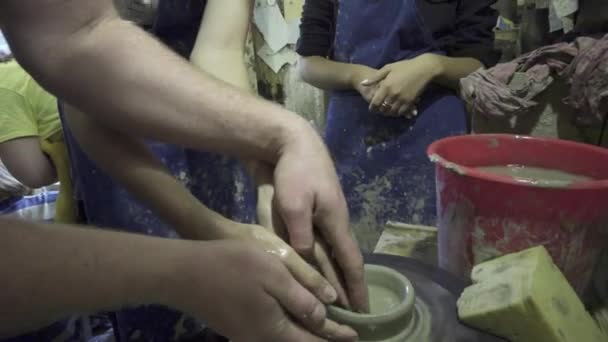Potter shapes the clay product with pottery tools on the potters wheel, craft factory authentic — Stock Video