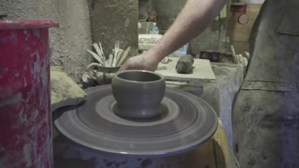 Поттер формує глиняний продукт з керамічними інструментами на гончарному колесі, ремісничий завод автентичний — стокове відео