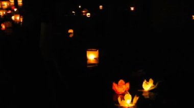 Adam kağıt fenerler suya düşürür.