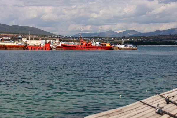 İki balıkçılık çubuklar üzerinde ahşap bir iskele yalan