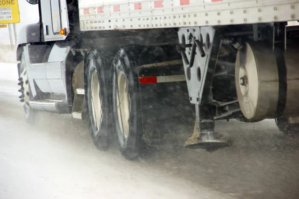 Truck tires spinning on highway during snowstorm