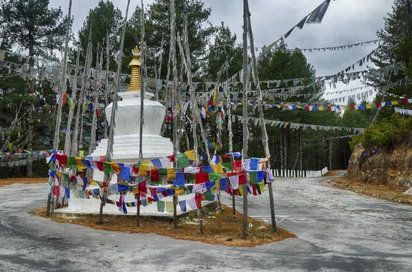 Chorten and  prayer flags  in the snow repeating mantra