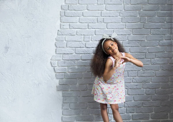 Linda chica afro contra la pared gris — Foto de Stock