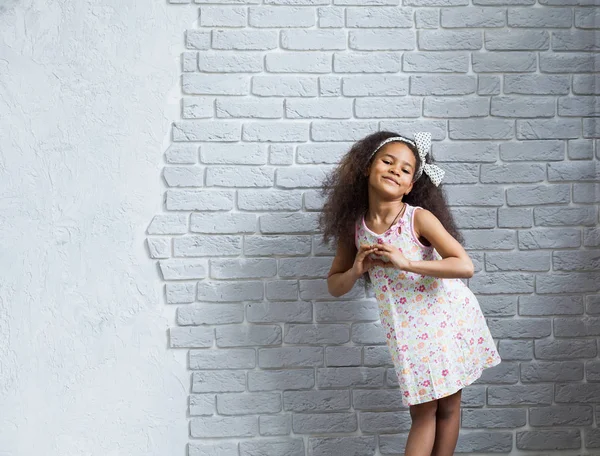 Nettes Afro-Mädchen gegen die graue Wand — Stockfoto