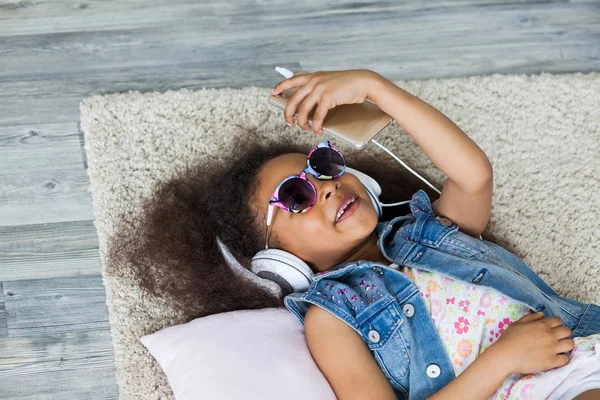 可爱的黑人女孩在家里听听音乐 — 图库照片