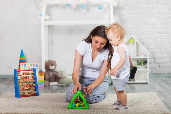 Madre y su hijo juegan juntos en interiores — Foto de Stock