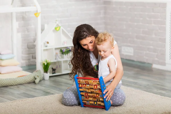 Moeder en haar zoon samen spelen indoor — Stockfoto