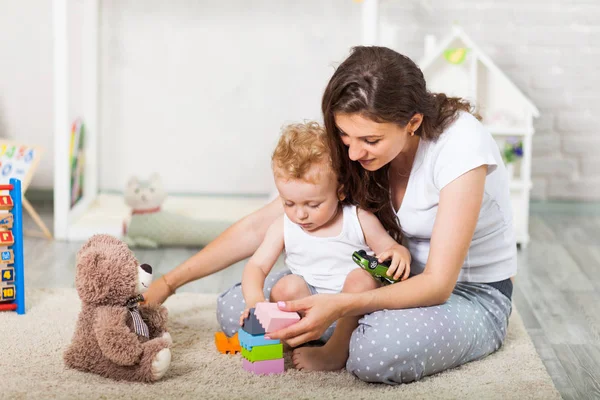 Mãe e seu filho jogar juntos interior — Fotografia de Stock