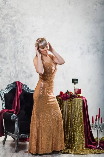 Menina bonita em um vestido dourado com uma coroa — Fotografia de Stock