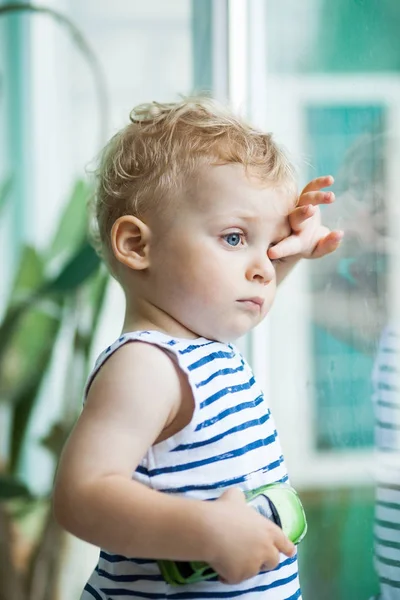 Niño viendo la lluvia a través de la ventana — Foto de Stock