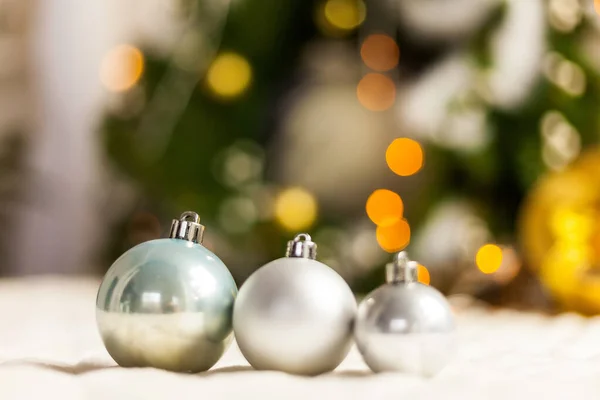 Três bolas de Natal pérola com bokeh colorido — Fotografia de Stock