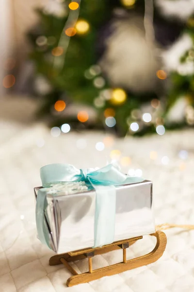 Caixa de presentes de papel brilhante no trenó de Natal. Conceito mínimo de Ano Novo. — Fotografia de Stock