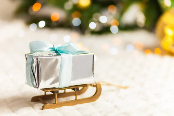 Caixa de presentes de papel brilhante no trenó de Natal. Conceito mínimo de Ano Novo. — Fotografia de Stock