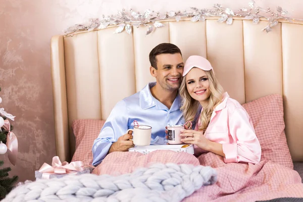 Happy family on Christmas morning in bed in pajamas — Stock Photo, Image