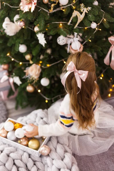 La niña decora el árbol de Navidad en la habitación. — Foto de Stock