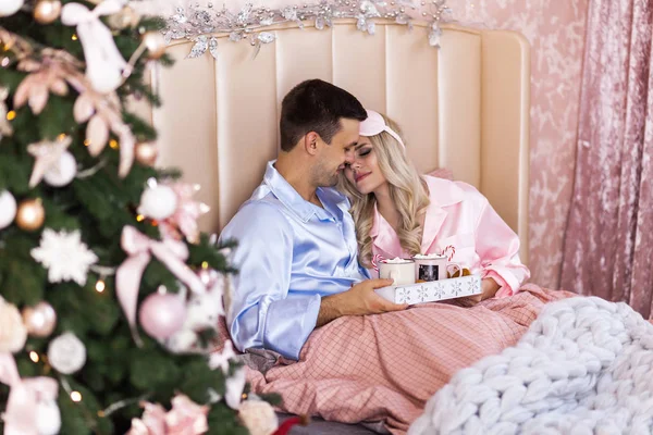 Lycklig familj på julafton i säng i pyjamas — Stockfoto