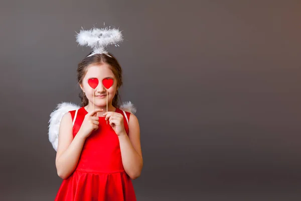 Χαμογελαστό κορίτσι με πλεξούδες διασκεδάζοντας, κλείνοντας το μάτι με γλειφιτζούρι σε σχήμα καρδιάς — Φωτογραφία Αρχείου
