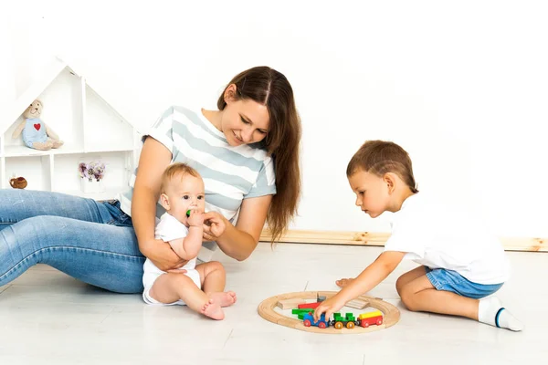 Mère assise avec des enfants jouant jeu à l'intérieur — Photo