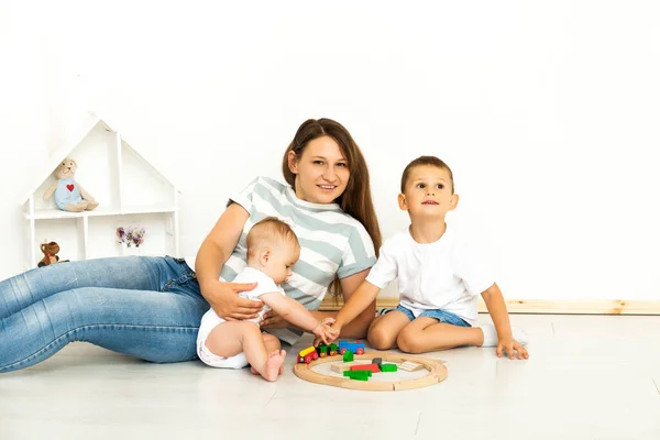 Madre sentada con los niños jugando al interior —  Fotos de Stock